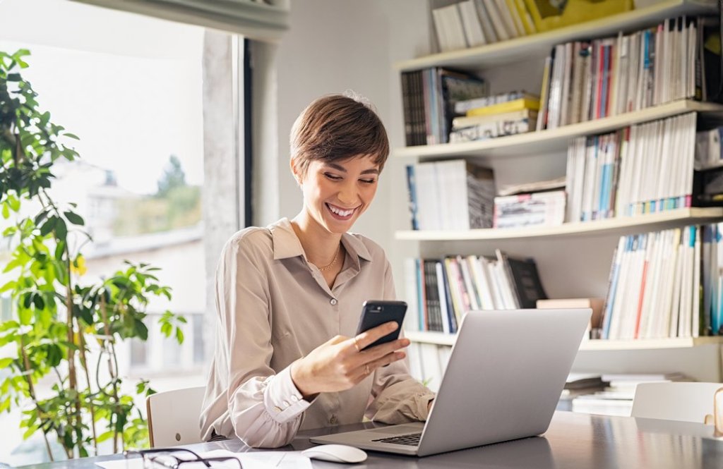 Eine junge Frau am Smartphone im Wohnzimmer. | Une jeune femme avec un smartphone dans le salon. | A young woman with a smartphone in the living room.